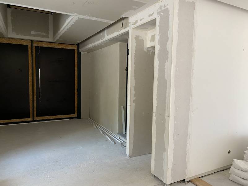 Conception d'une bibliothèque intégrée sur mesure en medium laqué blanc et niches en noyer massif pour une villa à La Ciotat